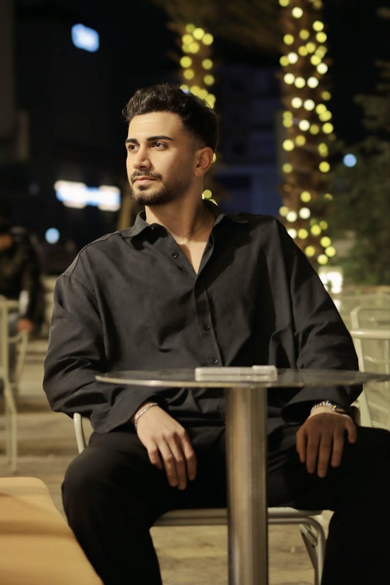 stylish man relaxing at a nighttime outdoor cafe